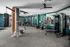 Well-equipped gym featuring a variety of exercise equipment and a brick column in the middle of the room at Abberly Foundry Apartments in Nashville, TN