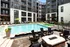 Outdoor swimming pool area featuring lounge chairs and a fire pit in front of an apartment building at Abberly Foundry Apartments in Nashville, TN