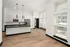 A kitchen and living room with white walls, hardwood floors, and open-concept living at Abberly Riverwalk Apartments in Nashville, TN