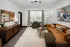 A spacious living room with a brown couch, a coffee table, and an open-concept kitchen featuring modern appliances at Abberly Riverwalk Apartments in Nashville, TN