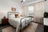A bedroom with a comfortable bed, a large window for natural light, and modern decor at Abberly Riverwalk Apartments in Nashville, TN