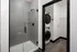 A large walk in glass shower with stacked washer and dryer at Abberly Riverwalk Apartments in Nashville, TN