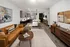 A spacious living room with a brown couch, a coffee table, and an open-concept kitchen featuring modern appliances at Abberly Riverwalk Apartments in Nashville, TN
