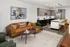 A spacious living room with a brown couch, a coffee table, and an open-concept kitchen featuring modern appliances at Abberly Riverwalk Apartments in Nashville, TN