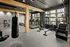 A gym with a large punching bag hanging from the ceiling, weights, and other modern exercise equipment at Abberly Riverwalk Apartments in Nashville, TN
