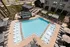 An aerial view of a resort-style pool with lounge chairs, umbrellas, and luxurious amenities at Abberly Riverwalk Apartments in Nashville, TN