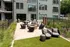 An outdoor patio with a firepit, wicker chairs, and modern outdoor amenities at Abberly Riverwalk Apartments in Nashville, TN