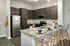 Kitchens with Dark Cabinetry and Stainless Steel Appliances at Abberly Solaire Apartments in Garner, NC