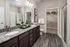Elegant bathroom featuring granite countertops, stylish dual sinks, and a spacious walk-in closet with chic decor.