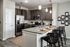 Modern kitchen with sleek granite countertops, stainless steel appliances, and elegant pendant lighting over a spacious island. Perfect for entertaining.