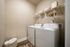 Modern laundry room with sleek washer and dryer, stylish shelving, and organized space for a clutter-free home.