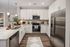 Modern kitchen with sleek stainless steel appliances, elegant granite countertops, and stylish white cabinetry, perfect for gourmet cooking.