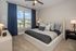 Cozy and elegantly designed bedroom with a plush king-sized bed, stylish cushions, and abundant natural light through large windows.