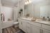 Luxurious modern bathroom featuring elegant double vanity with granite countertop, stylish decor, and calming neutral tones.