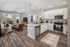 Modern open-concept living space with sleek kitchen, stainless steel appliances, and a cozy sitting area, exuding elegance and comfort.