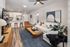 Contemporary open-plan living room with cozy white sectional sofa, stylish wooden coffee table, and a sleek kitchen island with barstools, perfect for entertaining.