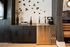 Chic apartment bar area with sleek stainless steel beverage dispenser, modern decor, and stylish cabinetry, perfect for entertaining.