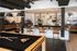 Chic and modern lounge area featuring a sleek bar with stylish stools, ambient lighting, and a pool table, ideal for entertainment and relaxation.