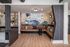 Modern lounge area with stylish seating, artistic wall design, and elegant lighting for a contemporary ambiance.