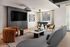 Modern apartment living room with stylish furniture, large TV, and foosball table, creating a perfect entertainment space.