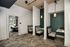 Modern office nook featuring cozy booth seating and stylish pendant lighting, with a conference room in the background.