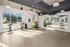 Bright and modern fitness room featuring exercise bikes, balance balls, and a mirrored wall with large windows offering scenic views.