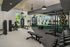 Modern fitness center with state-of-the-art gym equipment, weight racks, and natural light-filled surroundings.