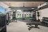 Modern fitness center featuring state-of-the-art exercise equipment, weight racks, and large windows providing natural light.