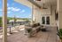 Chic rooftop lounge with stylish seating, modern decor, and scenic views under a clear blue sky.