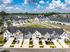 Charming suburban neighborhood with rows of modern townhouses, featuring manicured lawns and scenic surroundings, perfect for comfortable living.