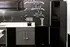 Modern kitchen space with sleek black appliances, stylish chalkboard accent wall, and unique tap dispenser.