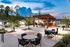 Charming outdoor patio at dusk with stylish seating, string lights, and lush landscaping, creating an inviting ambiance for relaxation and entertainment.