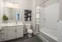 Contemporary bathroom with a sleek vanity, modern fixtures, and elegant subway tile shower. Bright and inviting design.