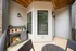 Charming outdoor patio with stylish wooden furniture, potted plants, and cozy atmosphere, perfect for relaxation and entertaining.