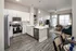 Modern open-concept kitchen and living room with sleek appliances, breakfast bar seating, and abundant natural light.