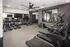 Modern fitness center with state-of-the-art treadmills, exercise bikes, and expansive mirrors, perfect for an energizing workout.
