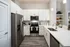 Modern kitchen featuring sleek stainless steel appliances, elegant white cabinetry, and a spacious countertop with bar seating.