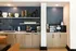Chic coffee bar with modern backsplash, elegant cabinetry, and decorative shelving in a contemporary designed space.