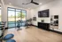 Sleek and modern fitness room featuring stationary bikes, yoga mats, and a striking wall mirror, perfect for energizing workouts.