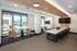 Modern meeting space with natural light, featuring a sleek conference table, comfortable seating, and large windows offering a vibrant outdoor view.