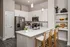 Chic modern kitchen with sleek white cabinets, stainless steel appliances, and inviting breakfast bar seating.