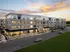 Modern apartment complex at sunset with illuminated windows, welcoming entrance, and ample parking space.