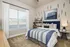 Inviting bedroom featuring a stylish blue and white color scheme with modern decor and ample natural light.
