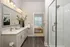 Elegant bathroom with double vanity, sleek glass shower, and view into cozy bedroom.