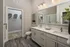 Modern bathroom featuring elegant dual sinks, spacious vanity, and an adjoining walk-in closet with ample storage.