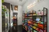 Chic apartment snack corner with vibrant shelves stocked with assorted snacks and gourmet treats, illuminated by a stylish neon sign, perfect for modern living.
