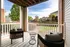 Charming apartment patio with cozy chairs overlooking landscaped garden and vibrant neighborhood view.