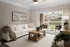 Inviting living room with chic decor, featuring a plush white sofa, stylish coffee table, and bright sliding doors opening to a cozy outdoor patio.