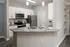 Modern kitchen with sleek granite countertops, stainless steel appliances, and elegant white cabinetry under soft pendant lighting.