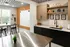Modern communal kitchen with sleek countertops, stylish cabinets, and vibrant decor, featuring a spacious window view.